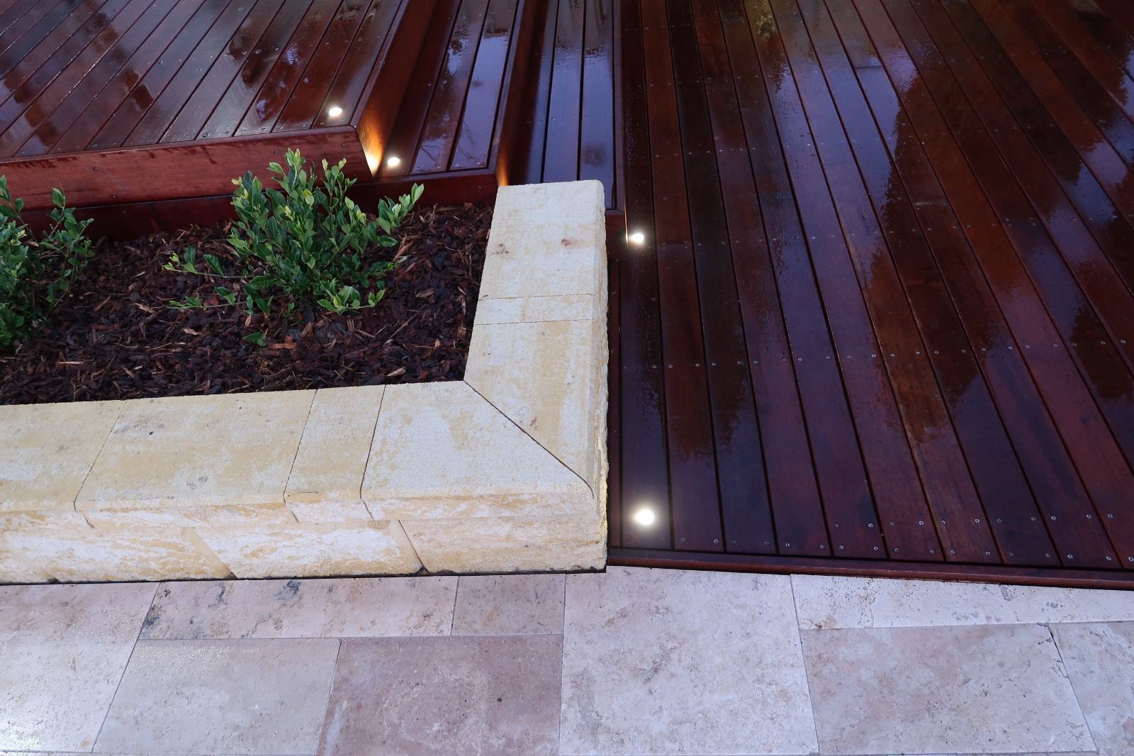 A corner of a wooden deck with lights on it