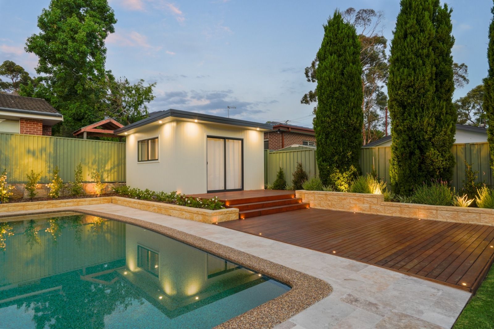 There is a swimming pool in the backyard of a house.