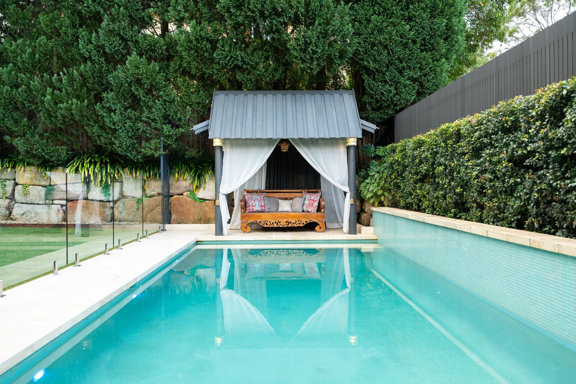 A swimming pool with a gazebo in the middle of it.