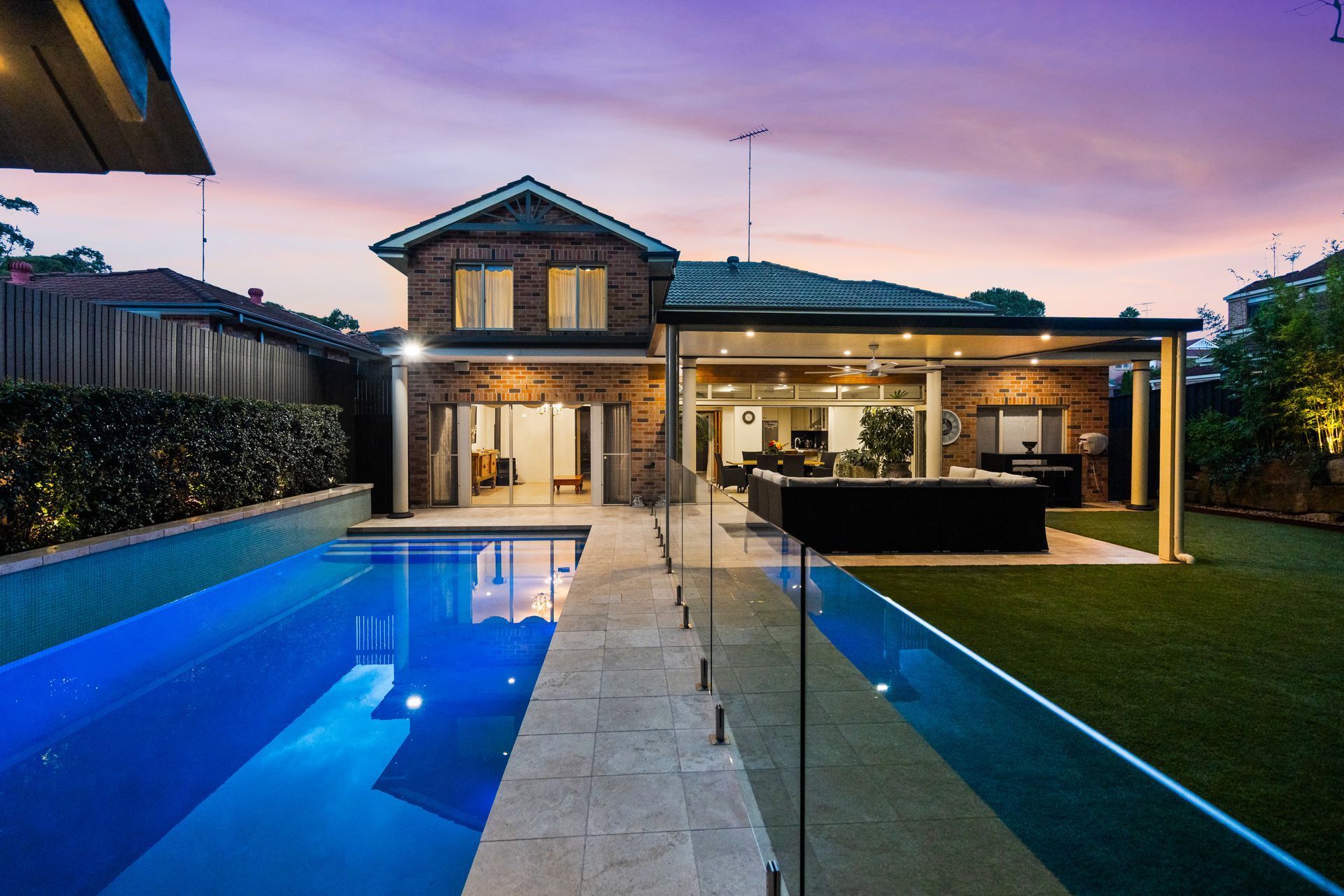 A house with a large swimming pool in front of it