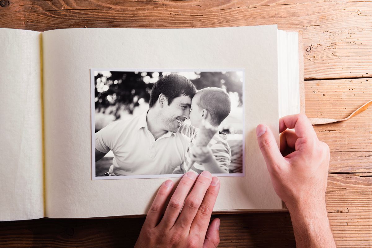 A person is taking a picture of a man and a boy in a photo album.