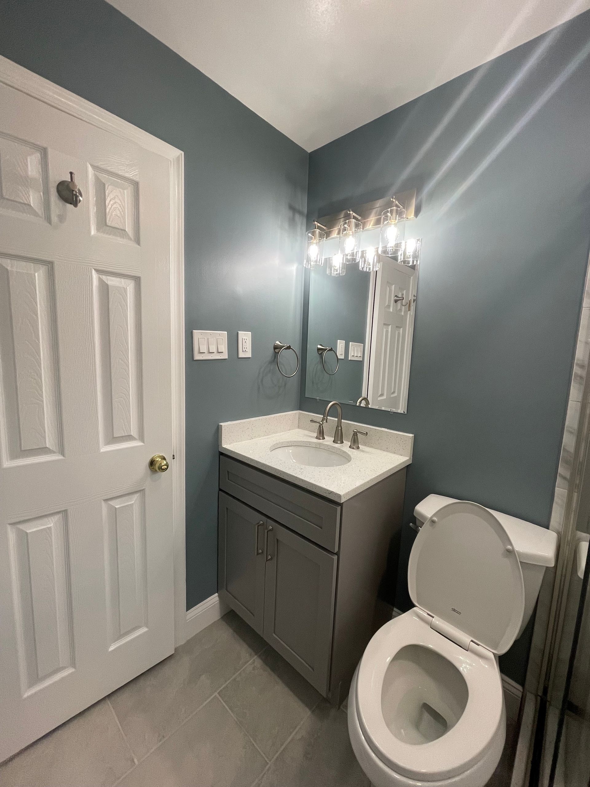 A bathroom with a sink , toilet and mirror.