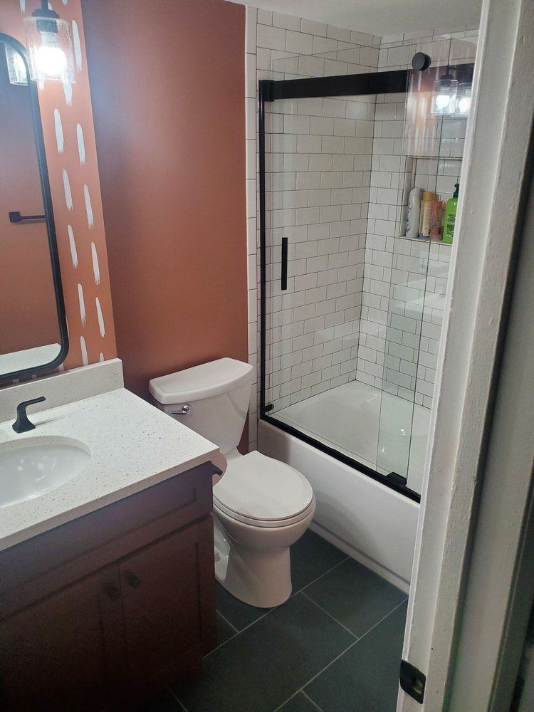 A bathroom with a toilet , sink , and bathtub.