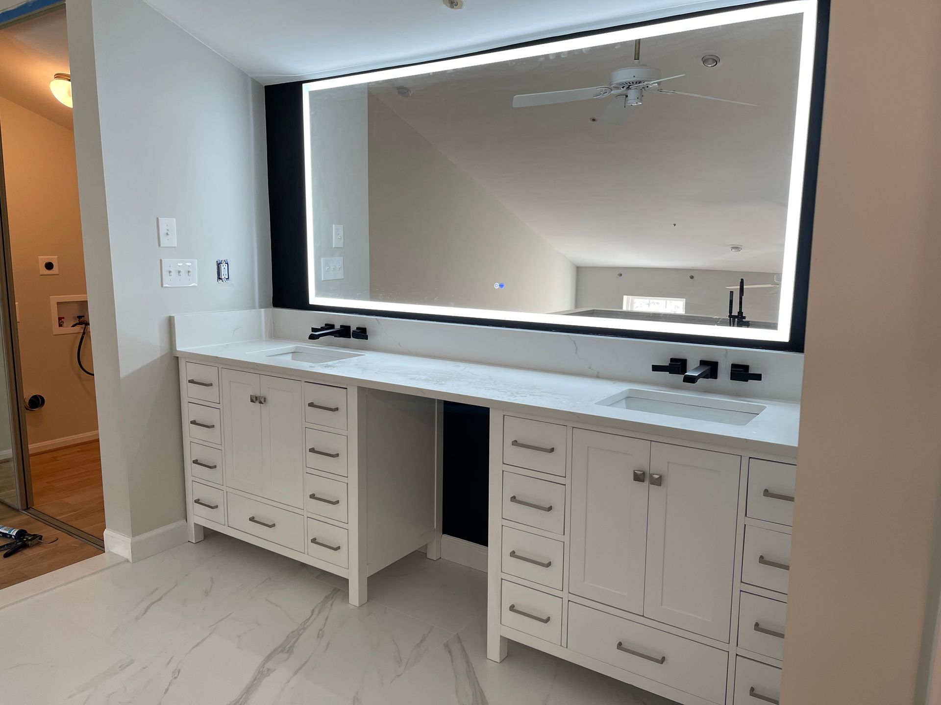 A bathroom with two sinks and a large mirror.
