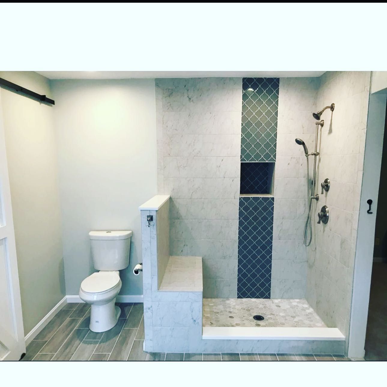 A bathroom with a toilet and a walk in shower
