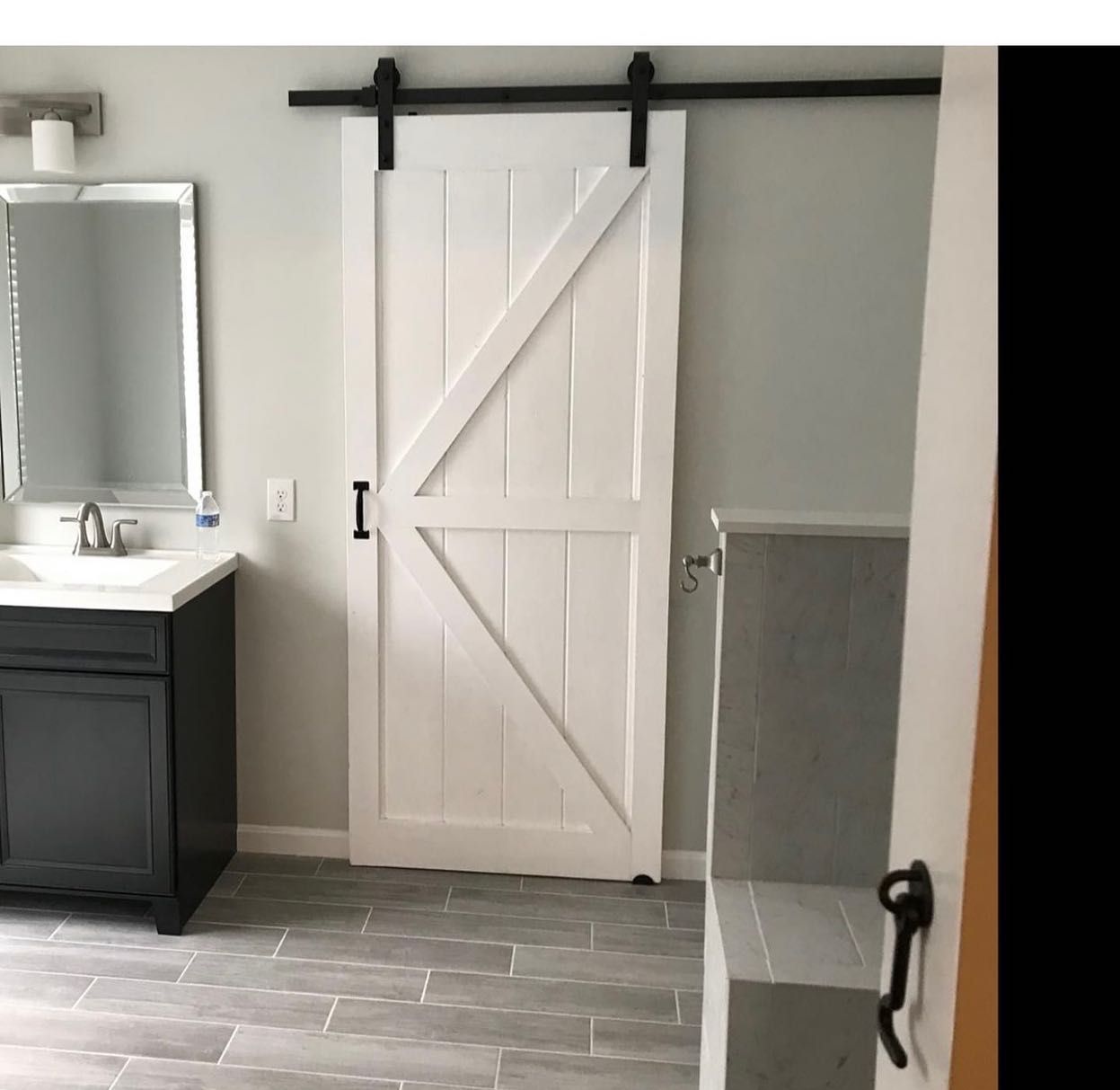 A bathroom with a sliding barn door and a sink