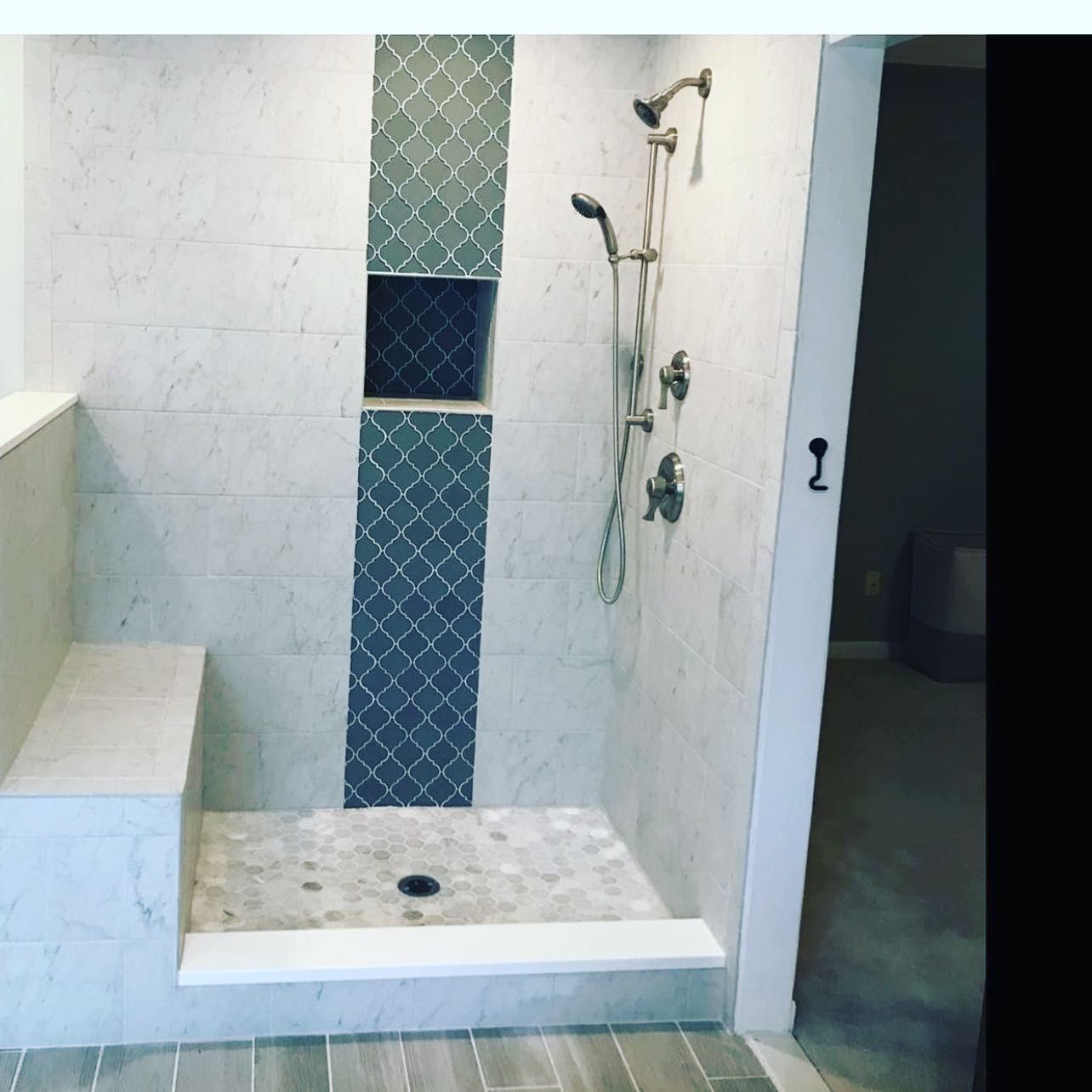 A bathroom with a walk in shower and a bench