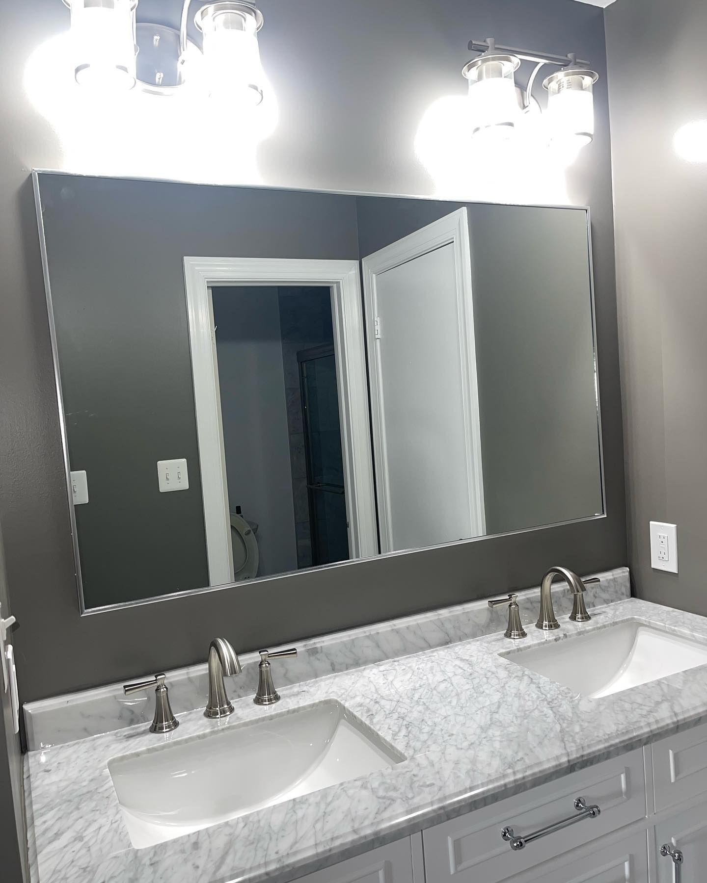 A bathroom with two sinks and a large mirror