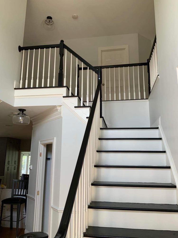 A white staircase with black steps and a black railing