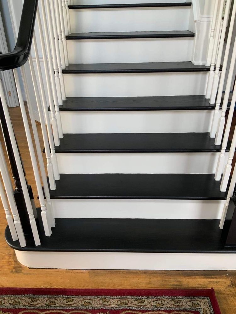 A staircase with black steps and white railings in a house.