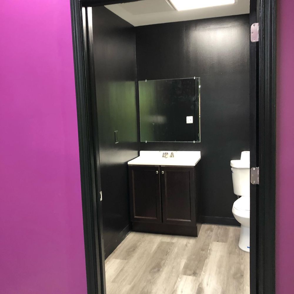 A bathroom with a toilet a sink and a mirror