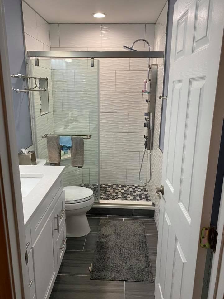 A bathroom with a toilet , sink , and shower.