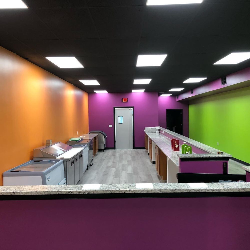 A kitchen with purple and orange walls and green counter tops