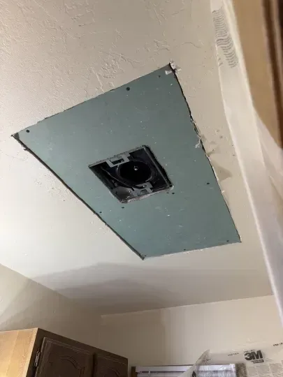 Ceiling with a rectangular drywall patch and exposed electrical box in a room
