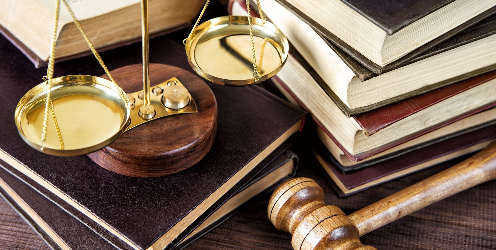 A wooden gavel is sitting on top of a stack of books.