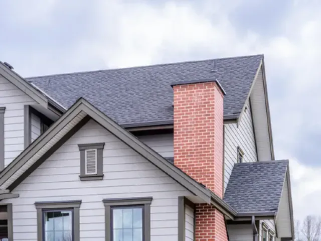 Chimney Sweep Portland- A large white house with a brick chimney on the roof.
