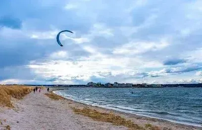 Chimney-Sweep-Portland-A person is flying a kite over a beach.