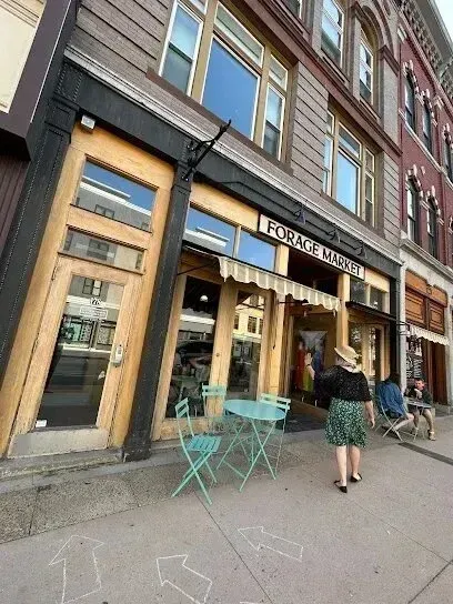 Chimney-Sweep-Portland-A woman in a hat is walking down a sidewalk in front of a building with the word theatre on it