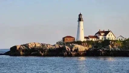 Chimney-Sweep-Portland-A lighthouse sits on top of a rocky island in the middle of the ocean.