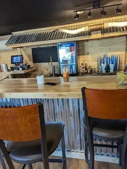 Chimney-Sweep-Portland-A restaurant with a bar and chairs and a refrigerator.