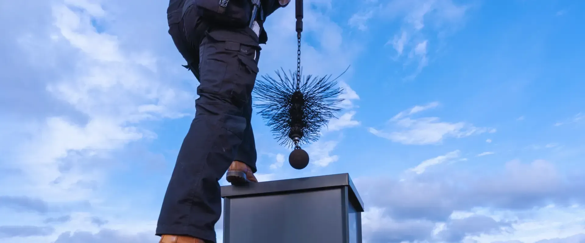 A man is cleaning a chimney with a brush.