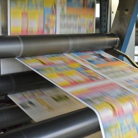 Printing press rollers feeding colorful pages through a press