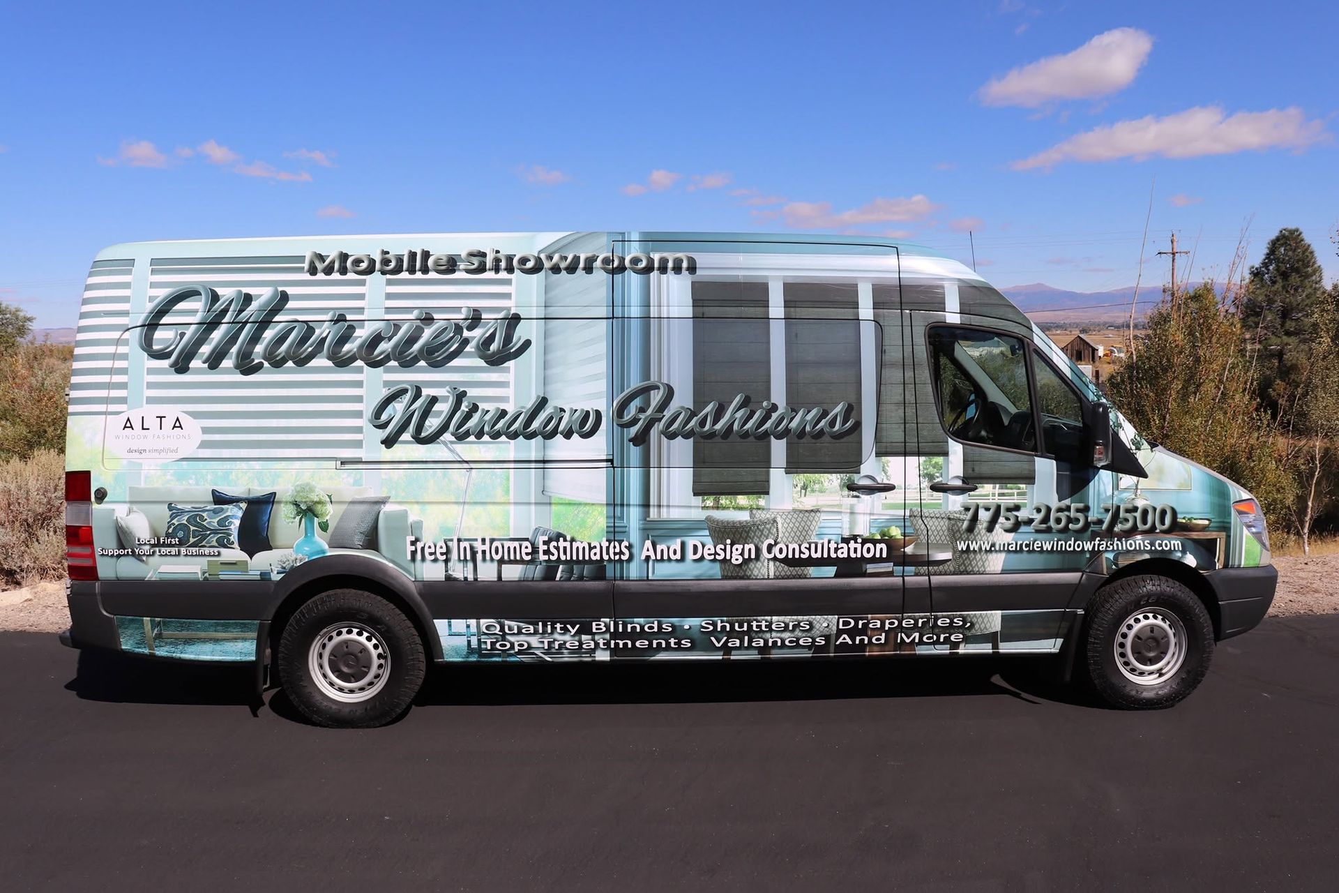 White decorated shuttle van with business lettering parked on a road in a desert landscape