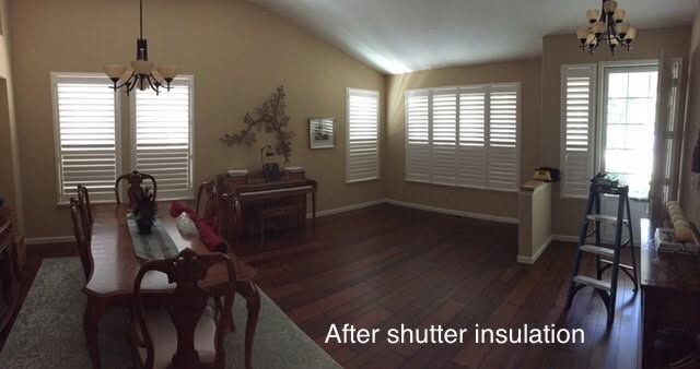 Empty living room with beige walls, dark wood floors, and text reading “After shutter insulation.”
