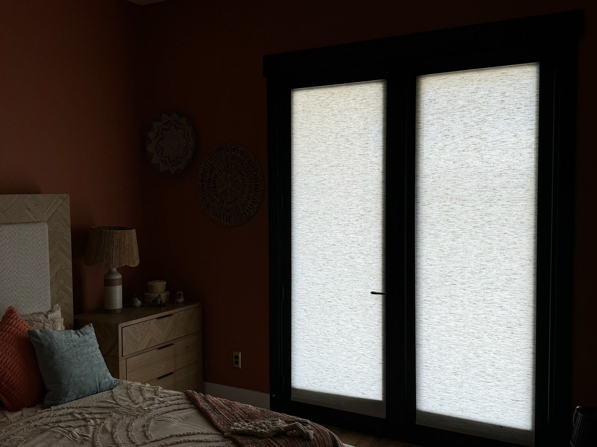Bedroom with twin frosted glass doors, a bed, nightstand, and warm red walls