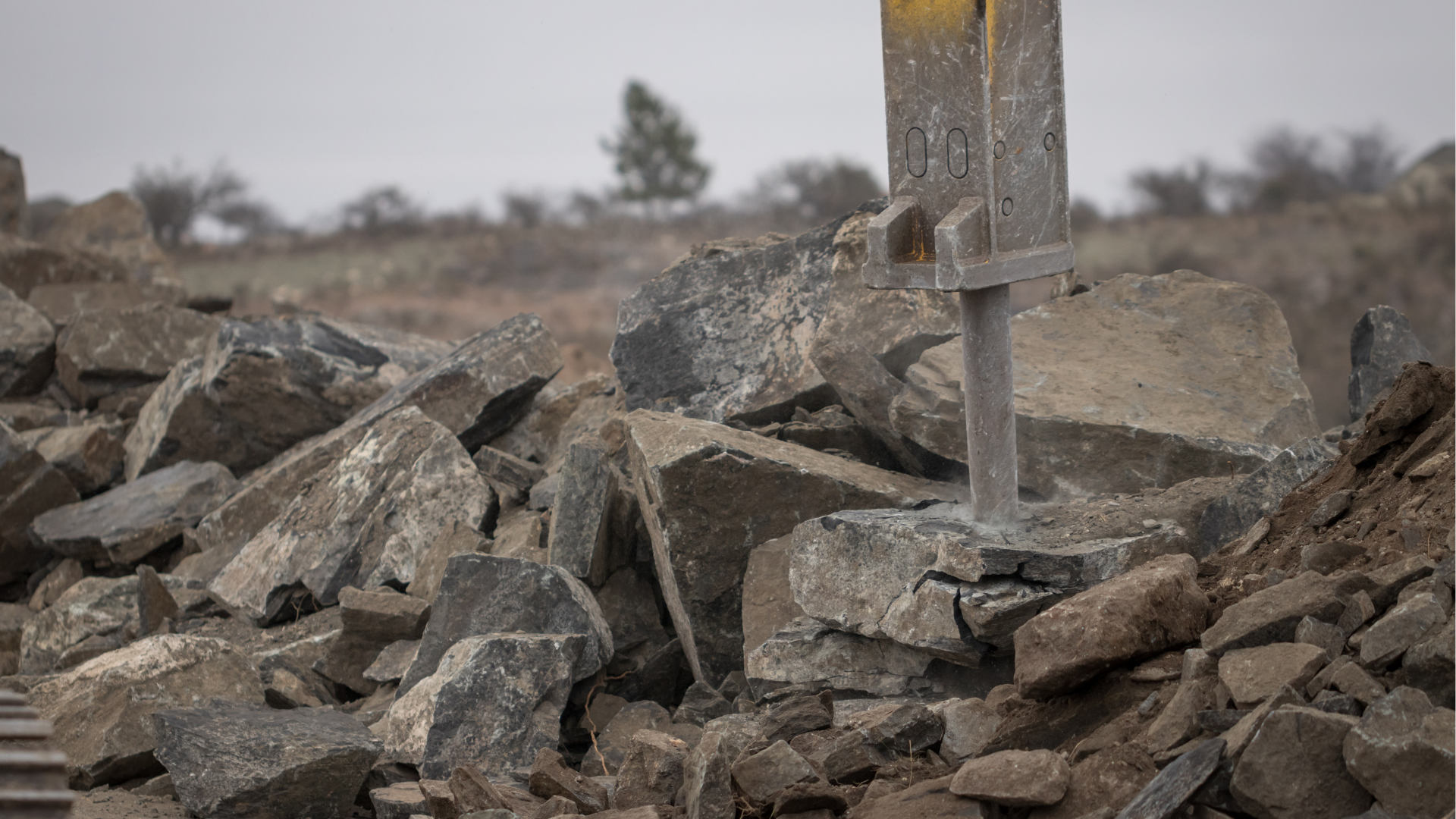 A pile of rocks with a yellow sign in the background.
