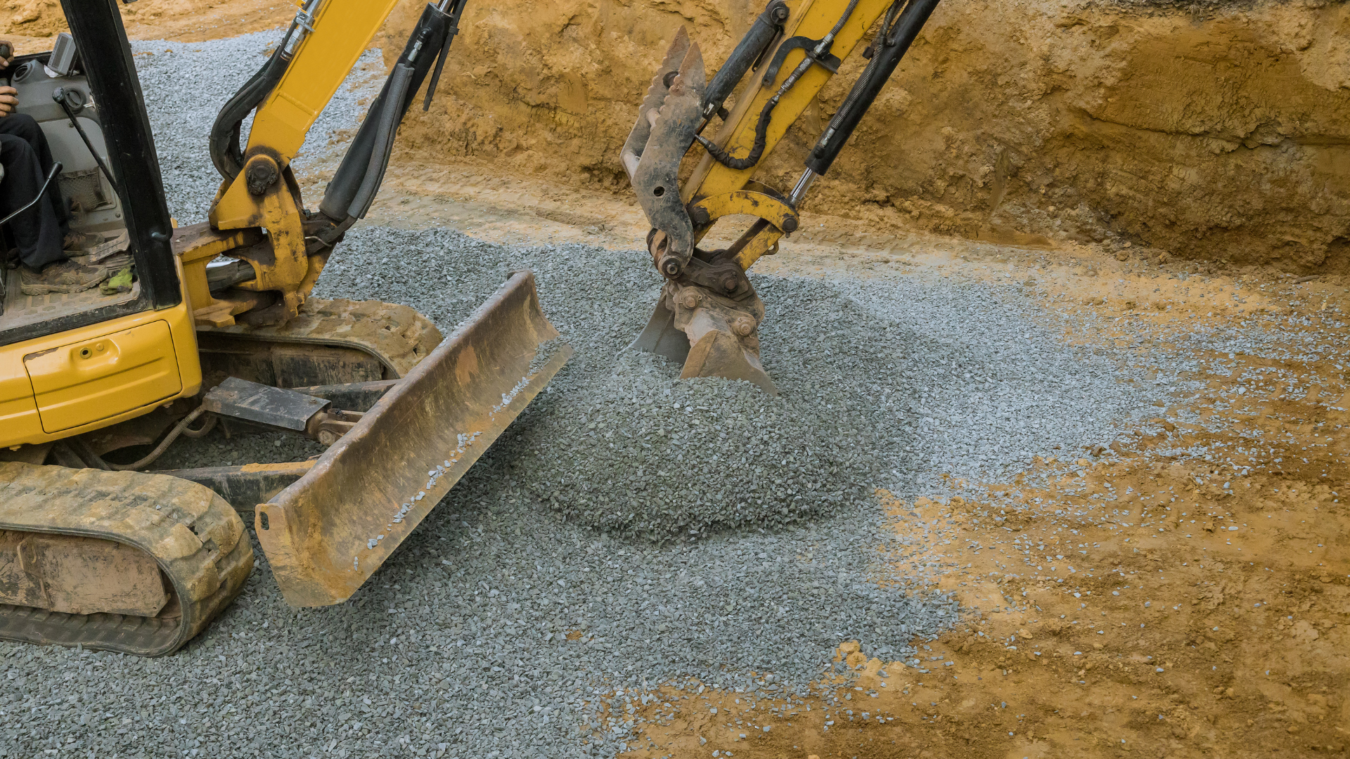 A yellow excavator is digging a hole in the ground.