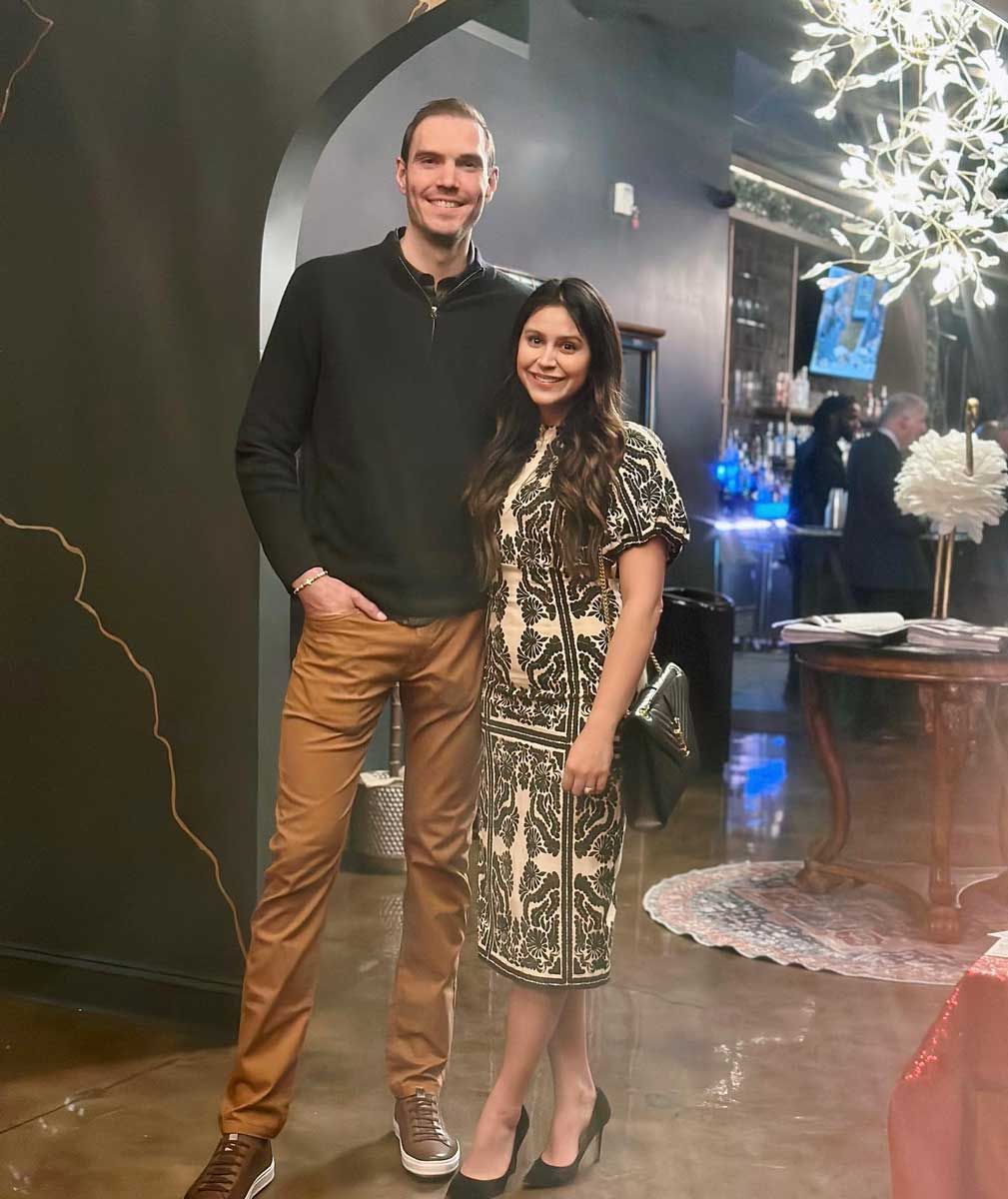 A man and a woman are standing next to each other in a room.