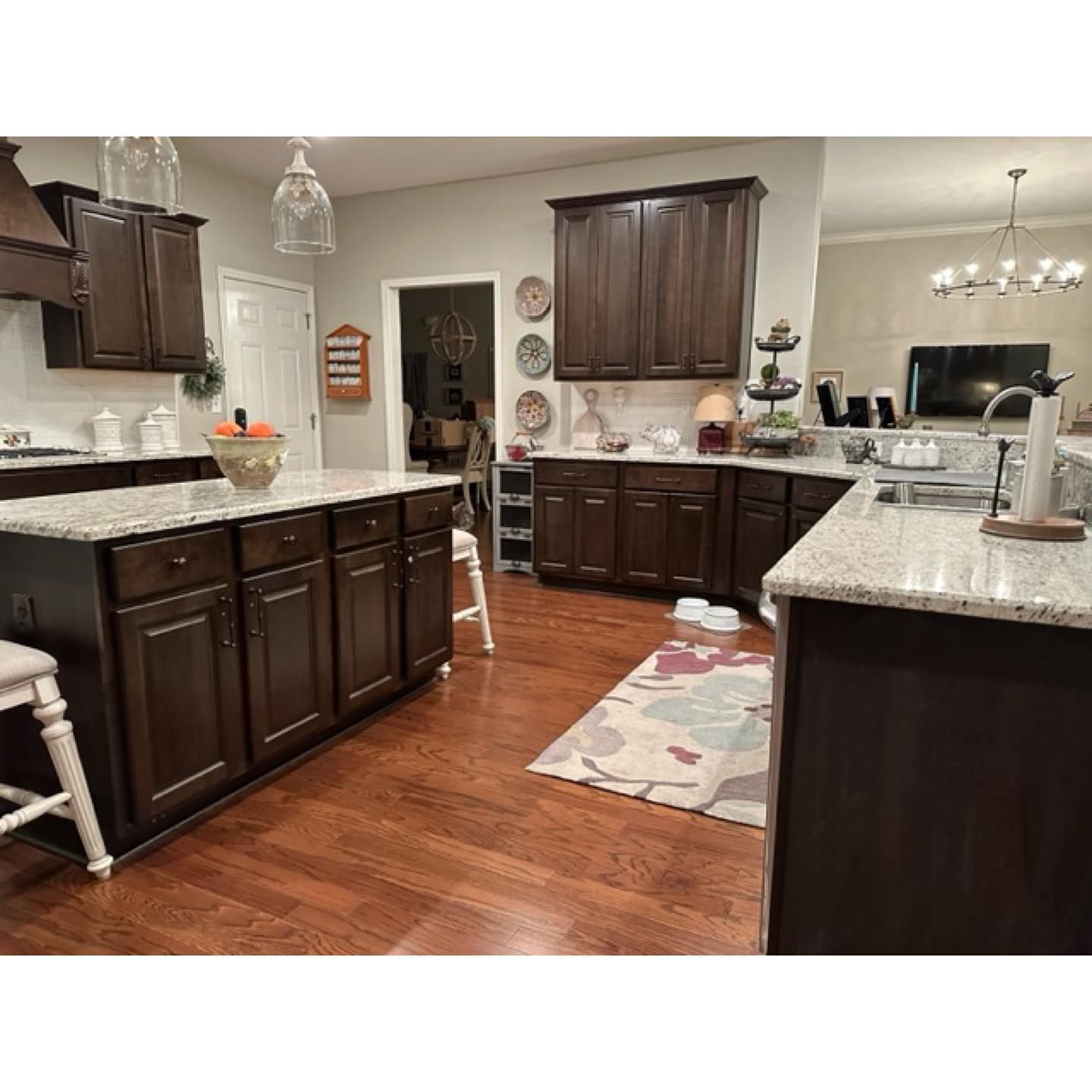 A kitchen with dark wood cabinets and granite counter tops.