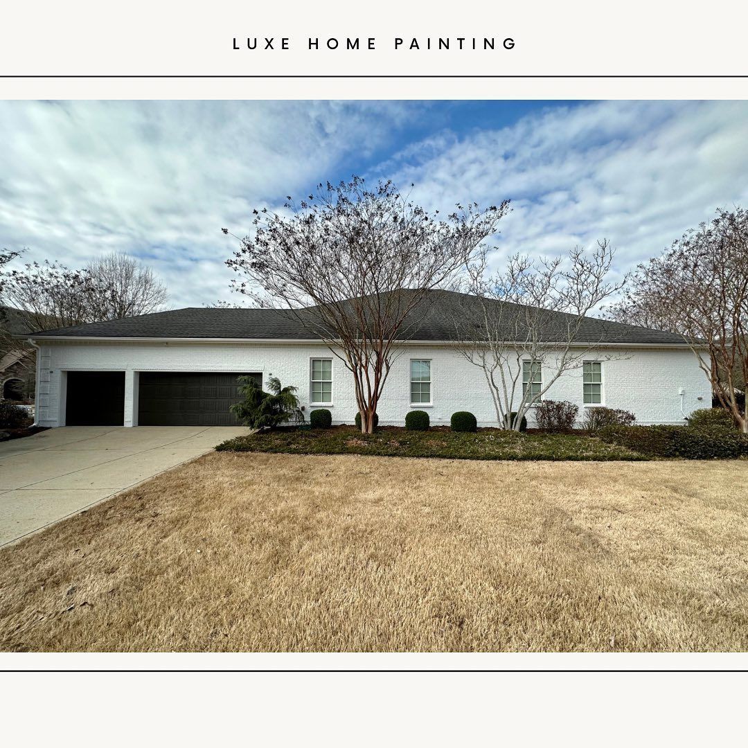 A white house with a black garage door is for sale.