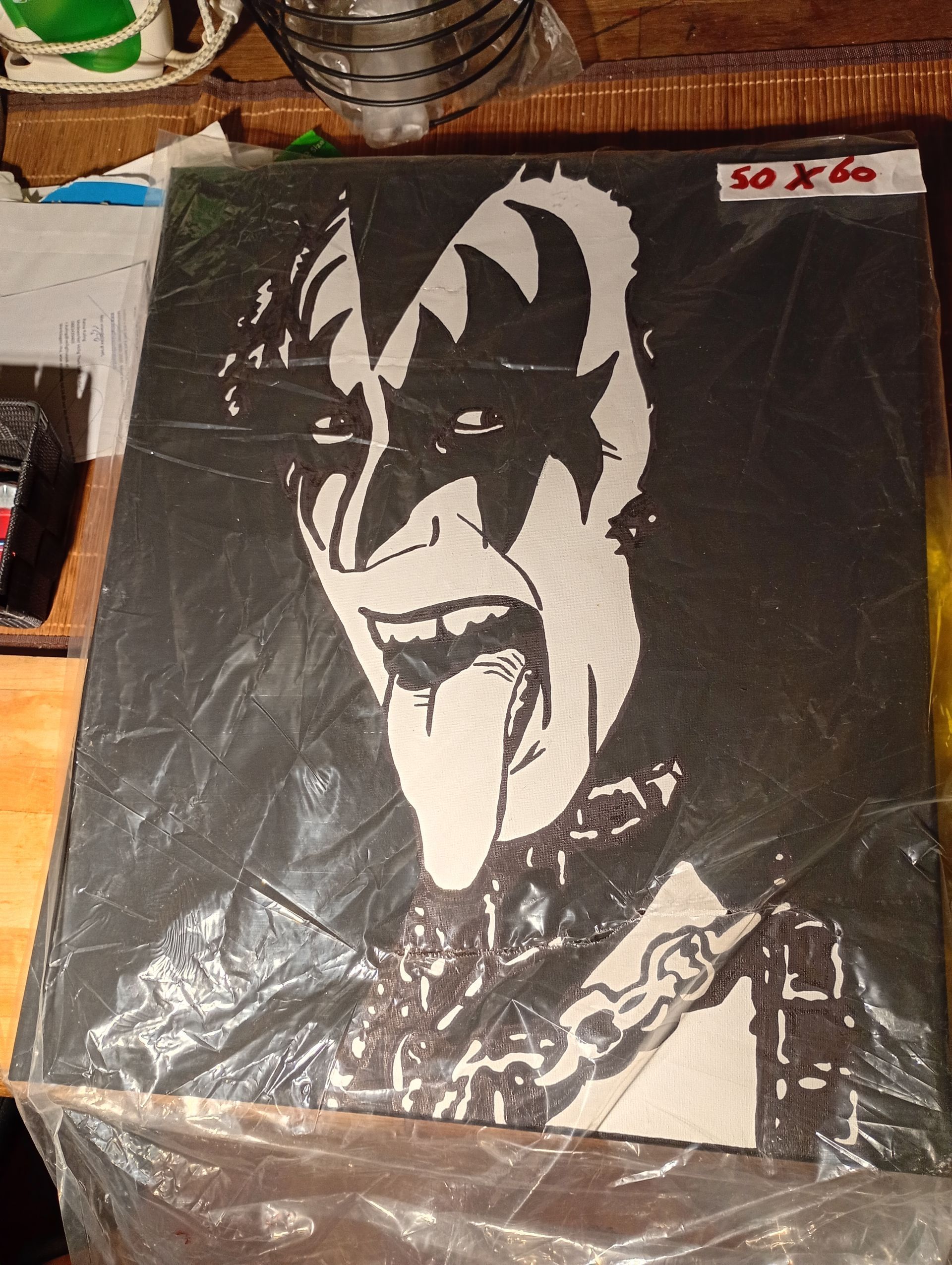 Portretkunst van Gene Simmons, zwart-wit, met uitgestoken tong, make-up en een kraag met studs.