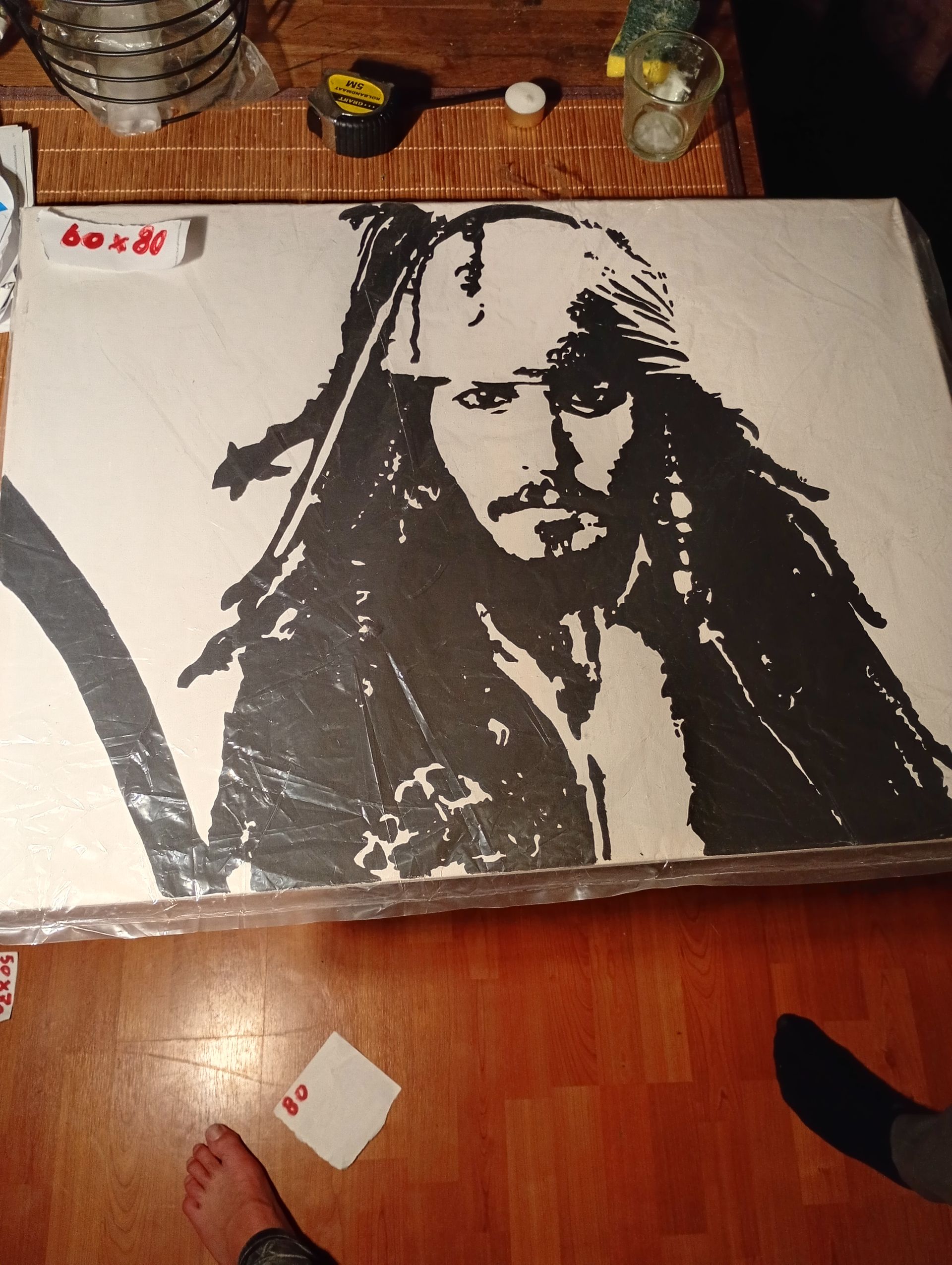 Zwart-wit stencilportret van Jack Sparrow op een canvas.