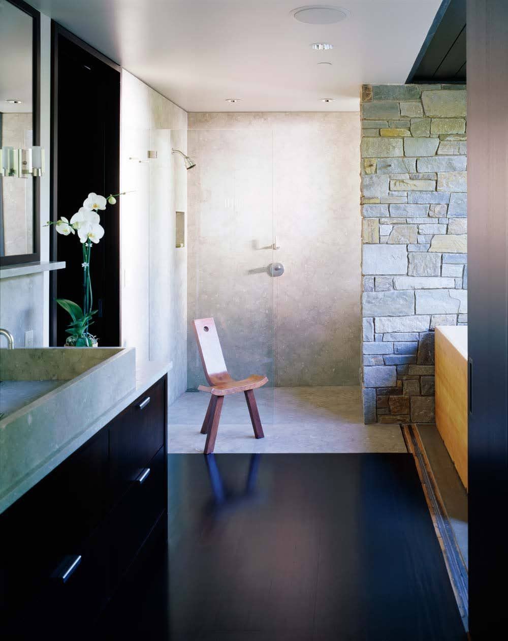 A bathroom with a sink and a chair in it