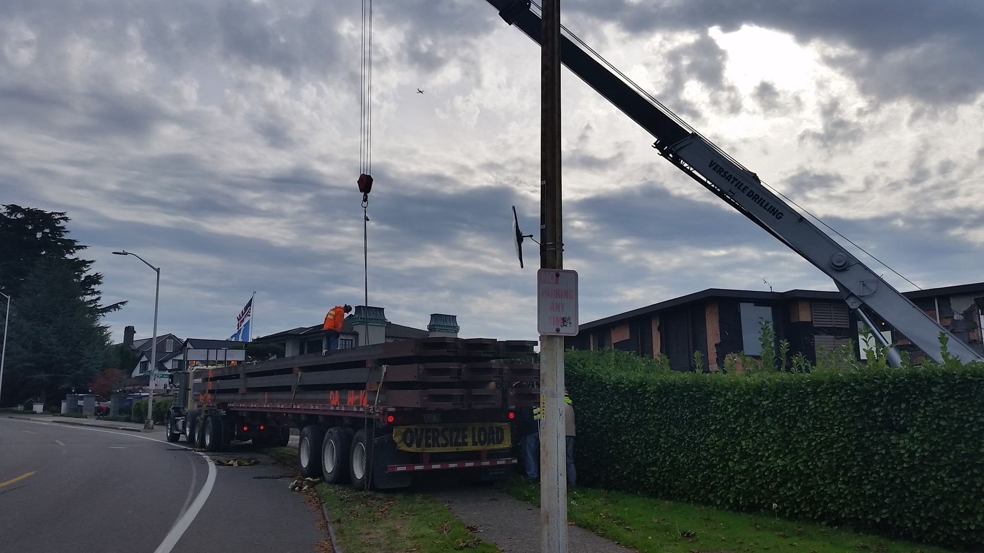 A truck is being lifted by a crane on the side of the road.