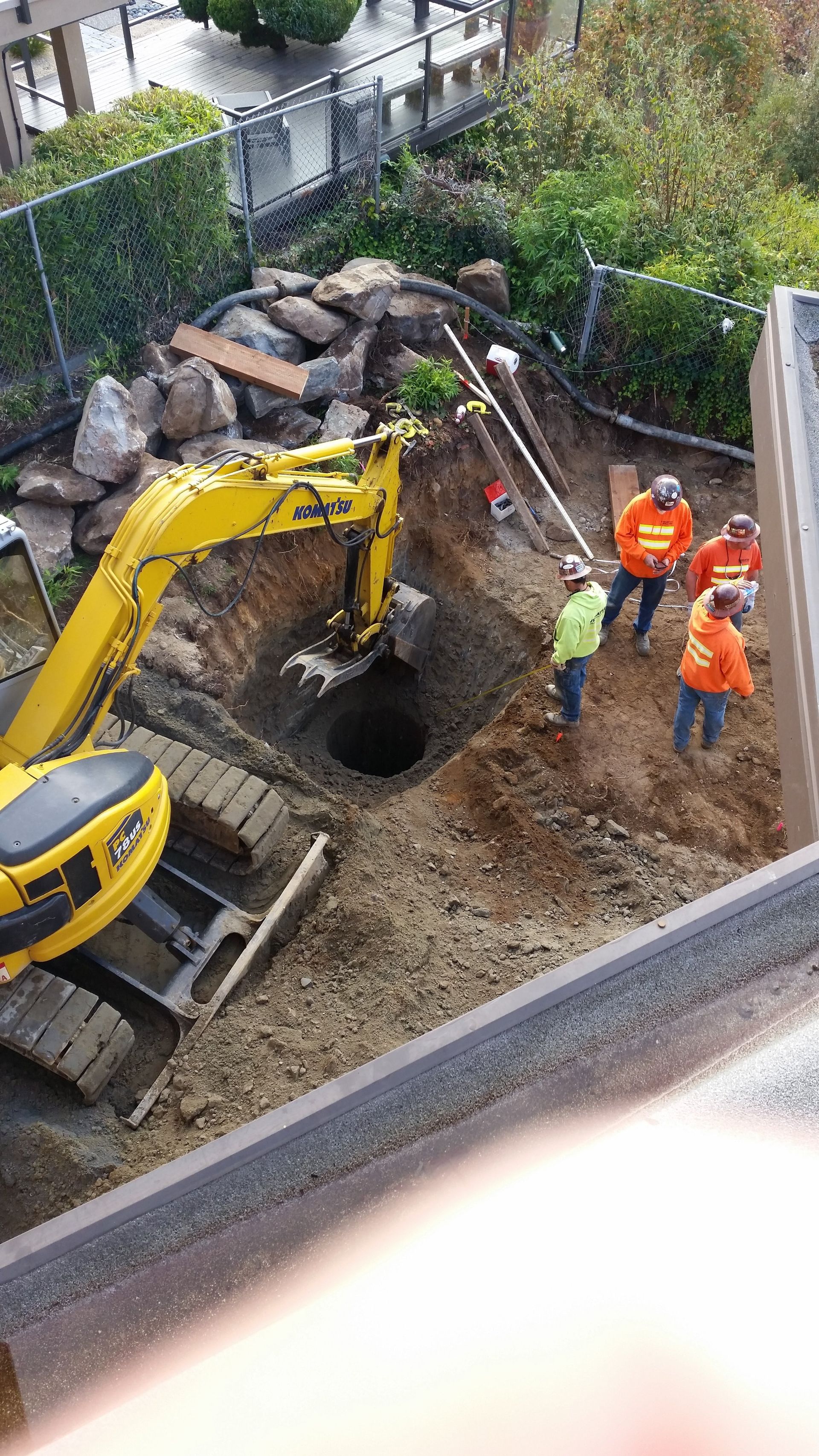 A group of construction workers are digging a hole in the ground.