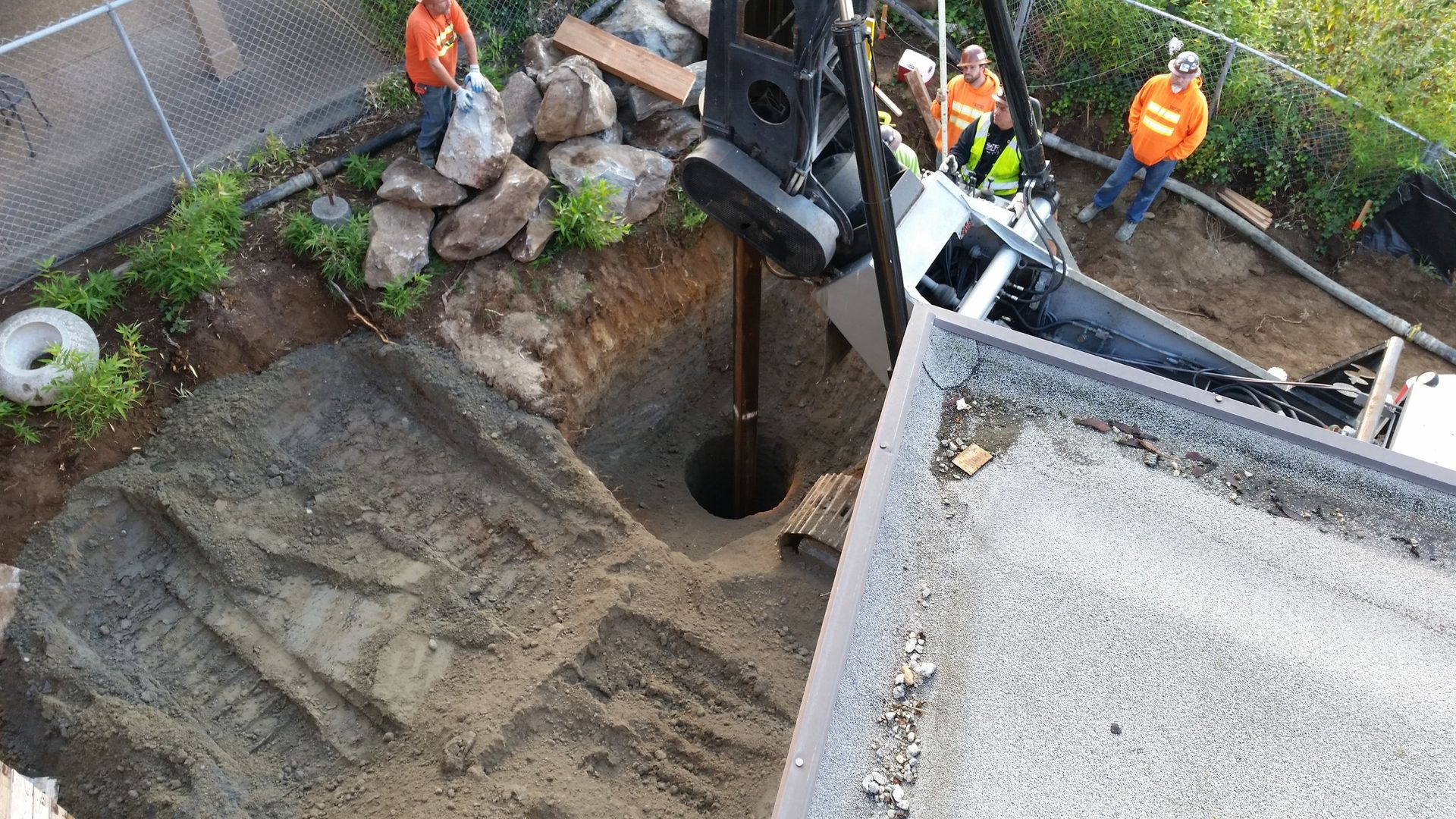 A group of construction workers are digging a hole in the ground.