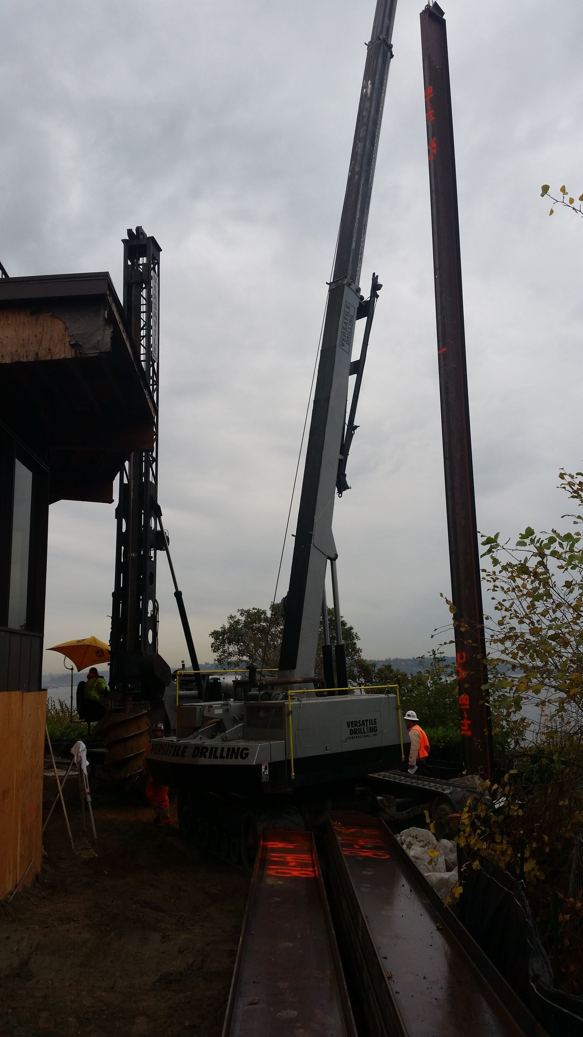 A large crane is sitting on top of a train track next to a building.