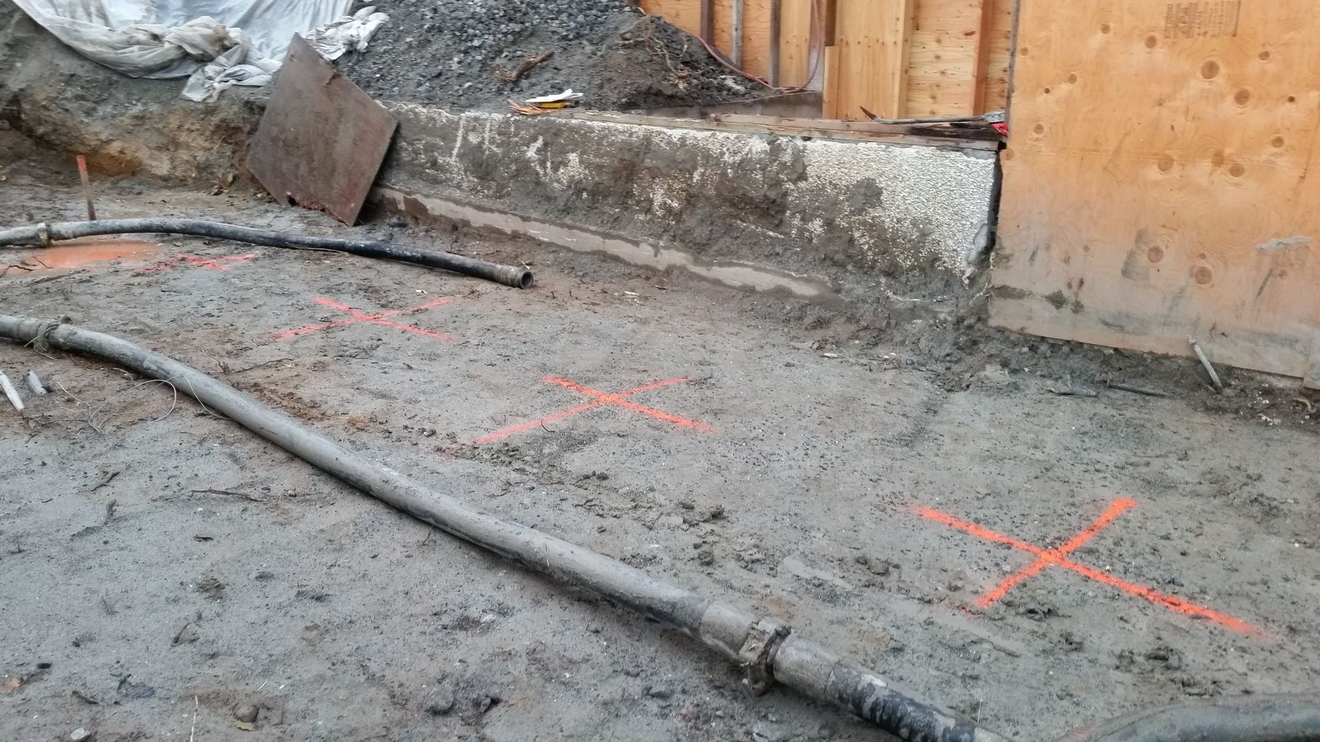 A hose is laying on the ground in a construction site.