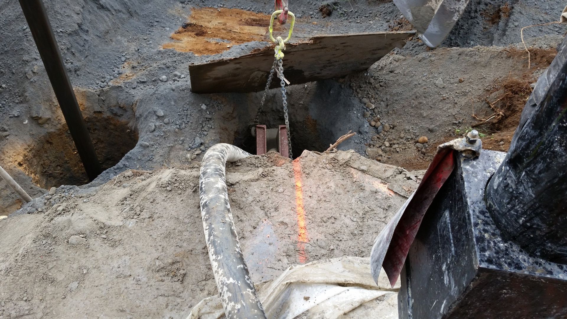 A chain is hanging over a hole in the ground