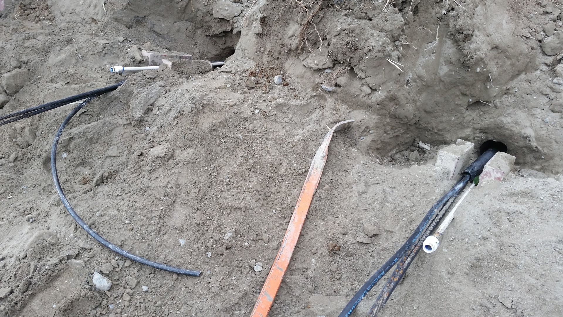 A bunch of wires are laying in the dirt.