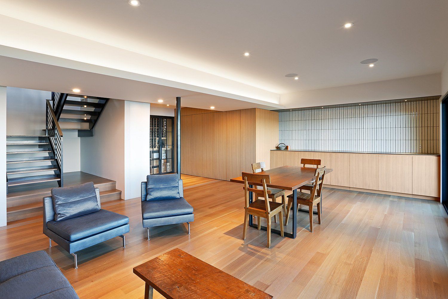 A living room with a table and chairs and a staircase.
