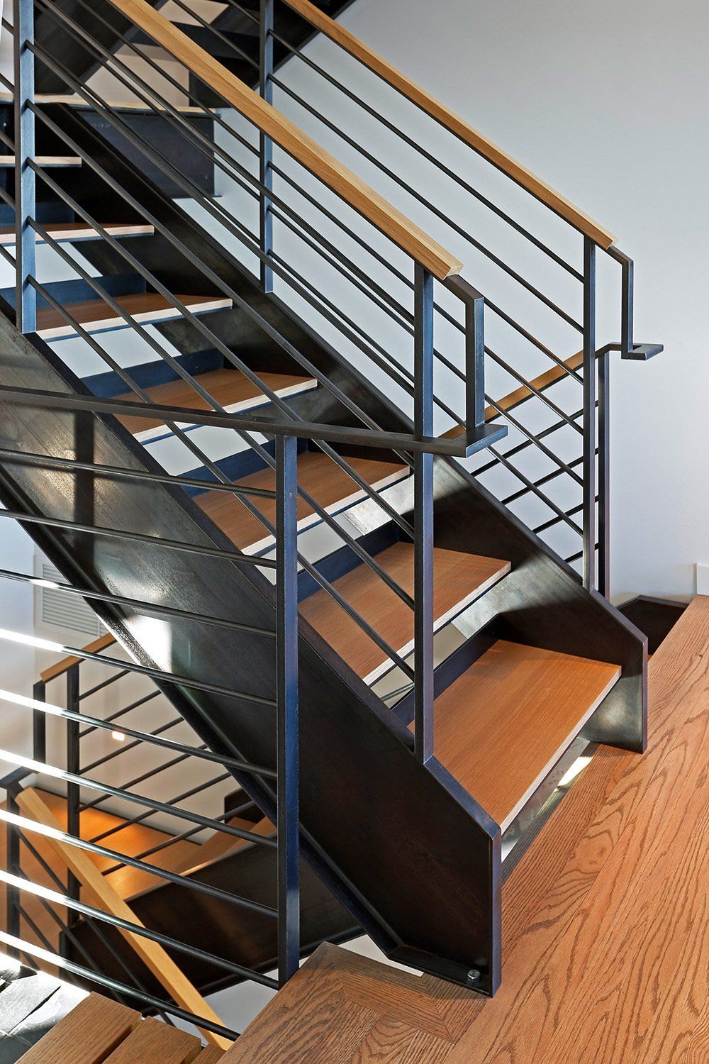 A staircase with a metal railing and wooden steps