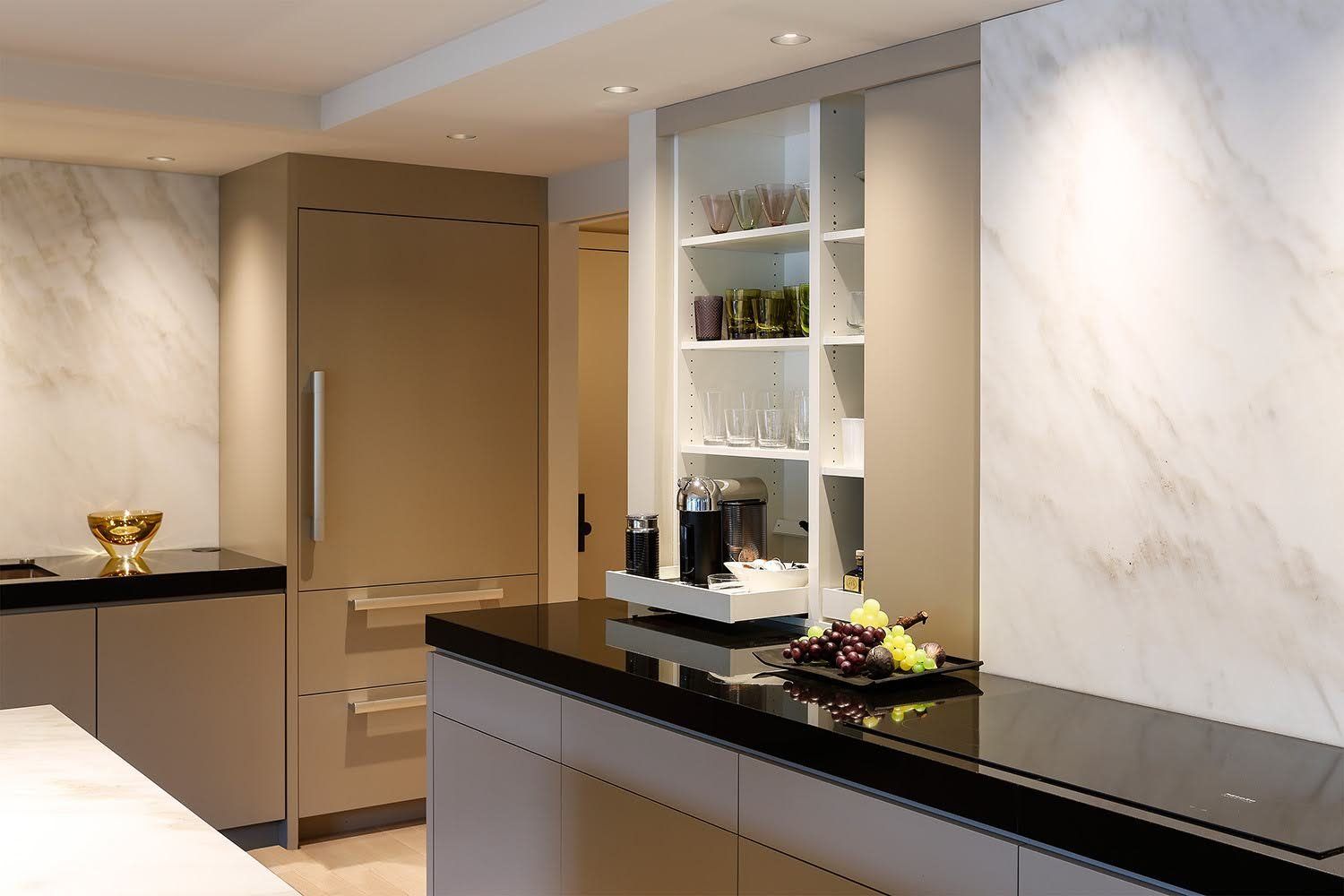 A kitchen with a black counter top and a marble wall