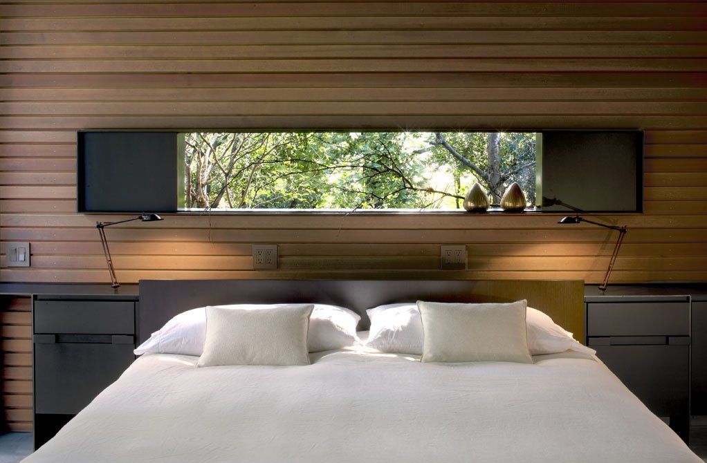 A bedroom with a large window over the bed