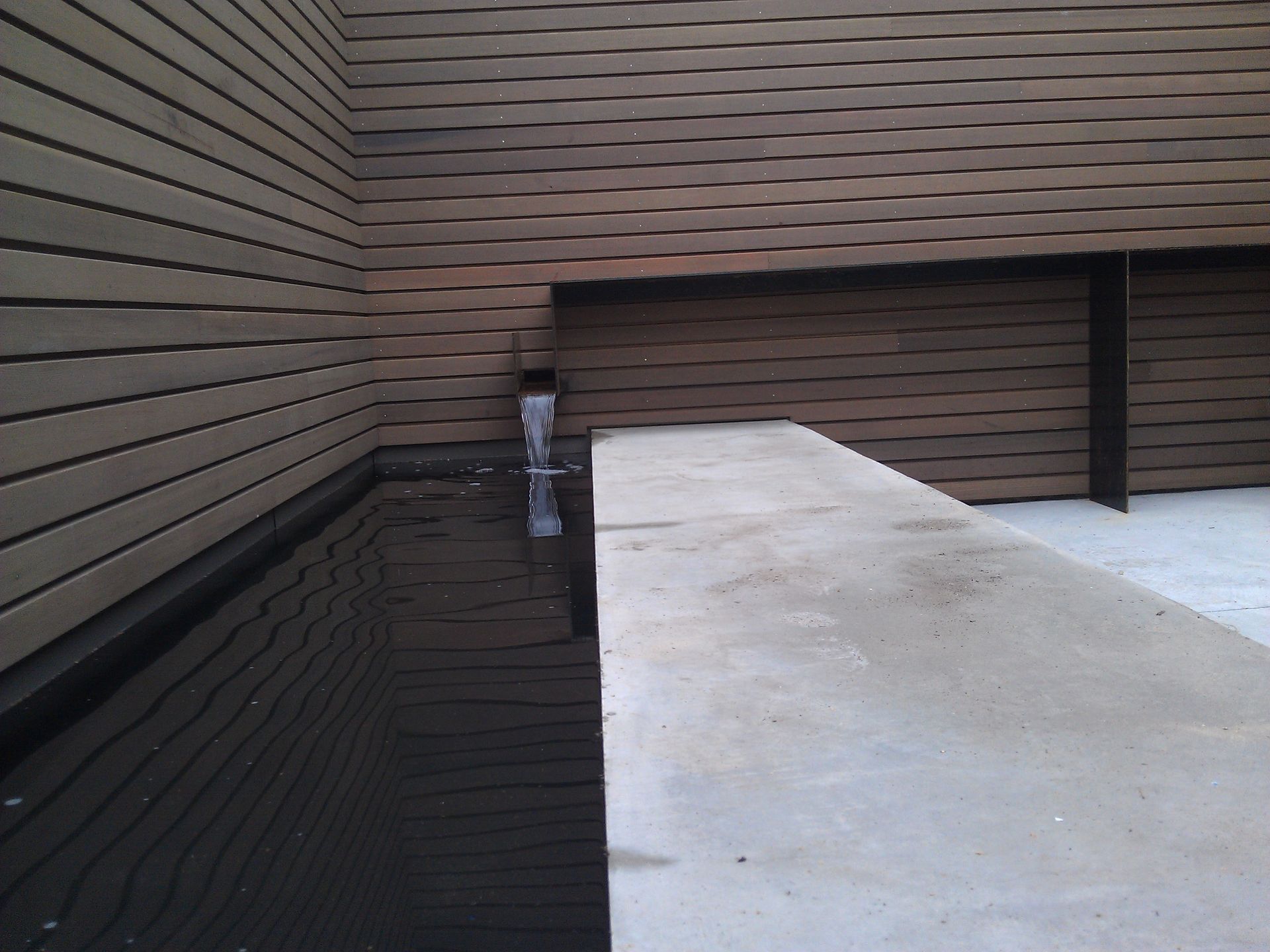 A corner of a building with a pool of water