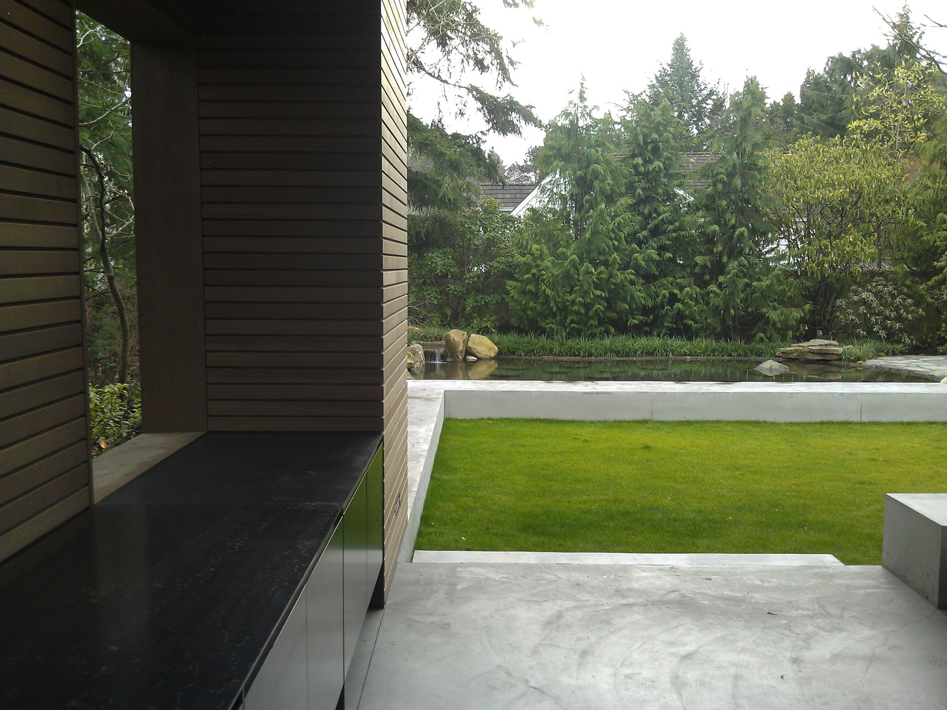 A lawn with a pond in the middle of it